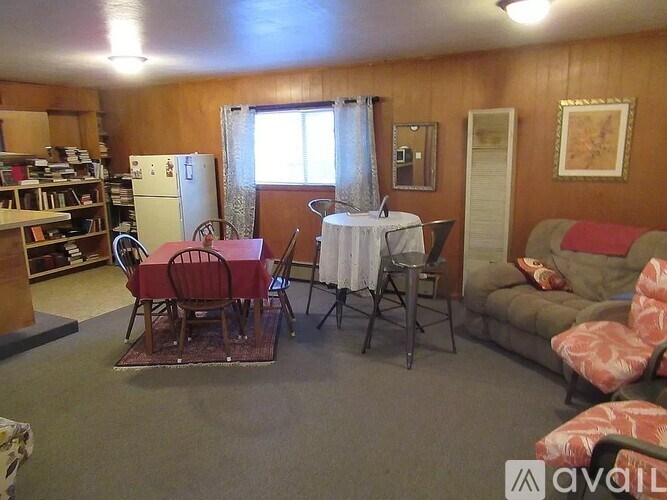 A living room with a dining table set up with chairs and a couch.