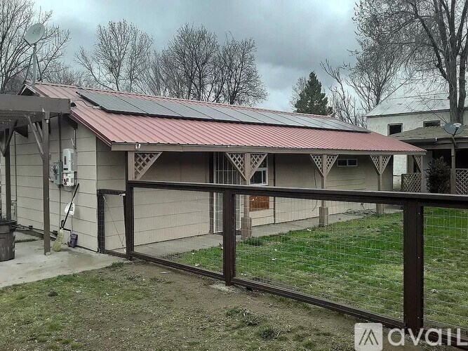 A house with a red roof and a brown fence.