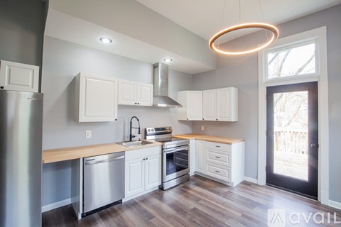 A modern kitchen with white cabinets and stainless steel appliances.