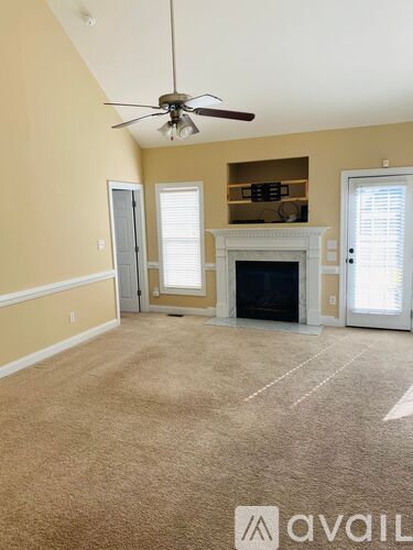 A living room with a fireplace and a ceiling fan.