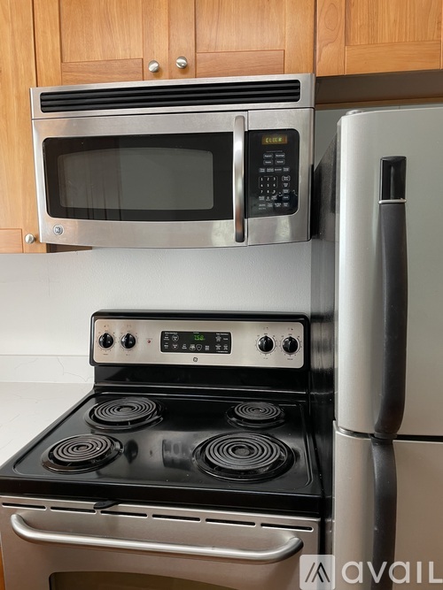 A modern kitchen with a stove, microwave, and refrigerator.
