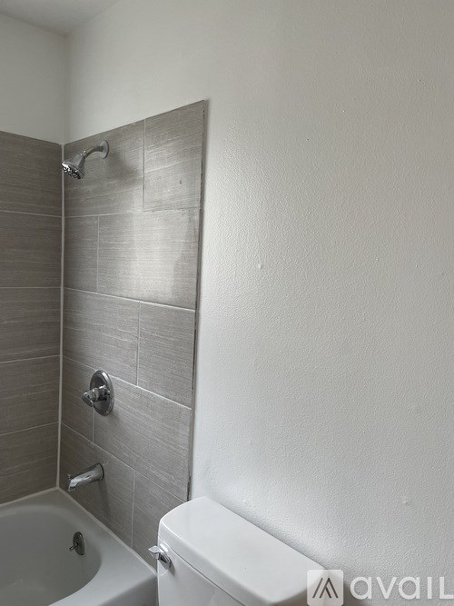 A bathroom with a white toilet and a tiled shower.
