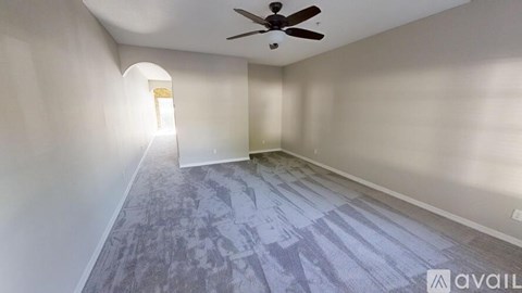 A room with a ceiling fan and a carpeted floor.