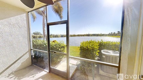 A balcony with a view of a body of water and trees.