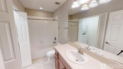 A bathroom with a white toilet, sink, and mirror.