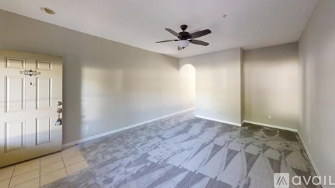 A room with a ceiling fan and a door with a lock.