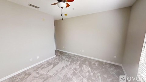 A room with a ceiling fan and a carpeted floor.