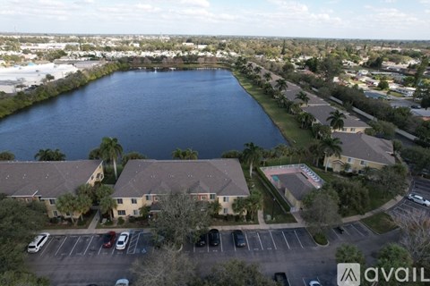 A bird's eye view of a residential area with a large body of water in the foreground and apartment buildings in the background.