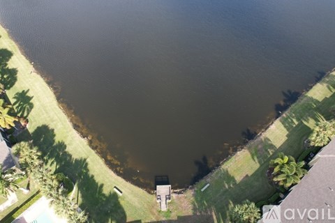 A large body of water surrounded by green grass and trees.