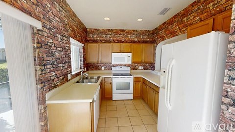 A kitchen with a white fridge, sink, and oven.