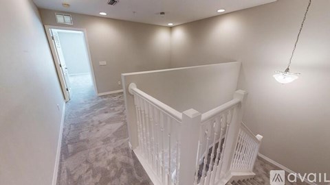 A spacious room with a staircase and a door in the background.