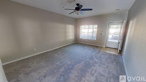 A room with a ceiling fan and a door leading to a balcony.