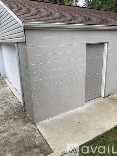 A grey building with a grey door and a grey roof.