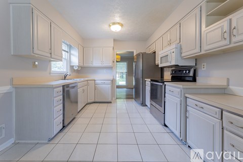 A kitchen with white cabinets and appliances.