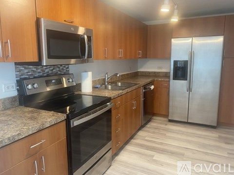 A kitchen with wooden cabinets and a stainless steel refrigerator.