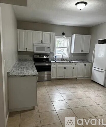 A kitchen with white cabinets and appliances.