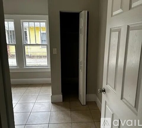 A white door is open to a dark hallway.