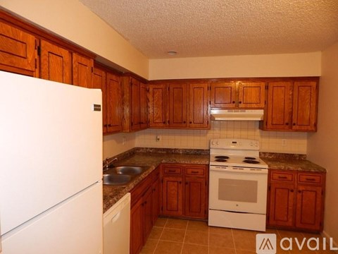 A kitchen with wooden cabinets and a white refrigerator.