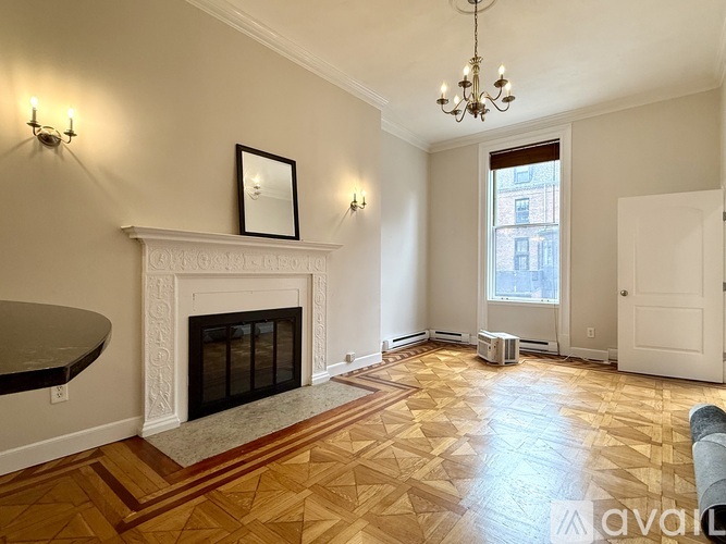A living room with a fireplace and a painting on the wall.