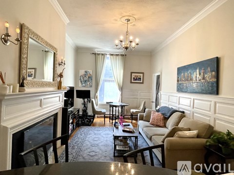 A living room with a fireplace and a painting on the wall.