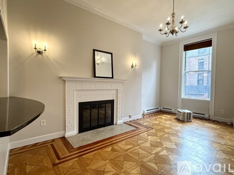 A living room with a fireplace, a sofa, a coffee table, and a chandelier.