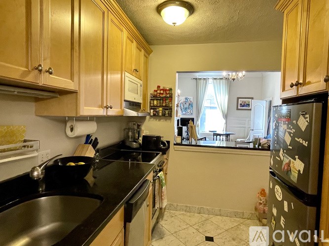 A kitchen with wooden cabinets and black countertops.