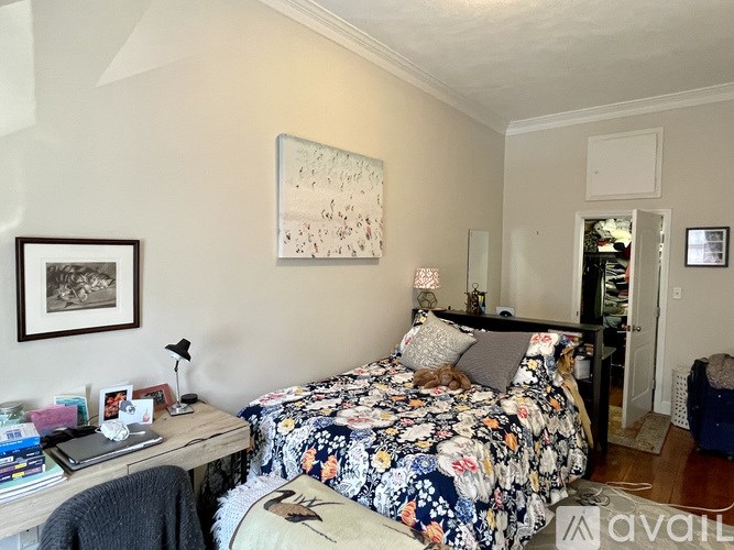 A bedroom with a bed, desk, and chair.