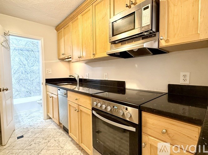 A kitchen with wooden cabinets and a black countertop.