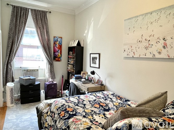 A bedroom with a large bed and a painting on the wall.