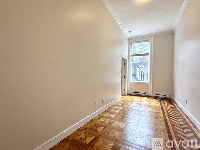 A living room with a grey couch and a fireplace.