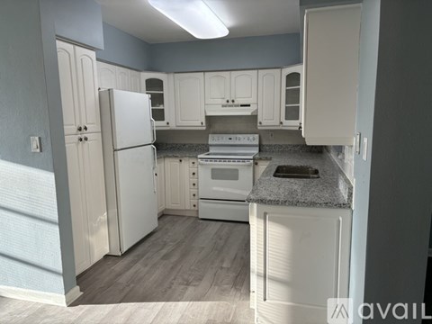 A kitchen with white appliances and cabinets.