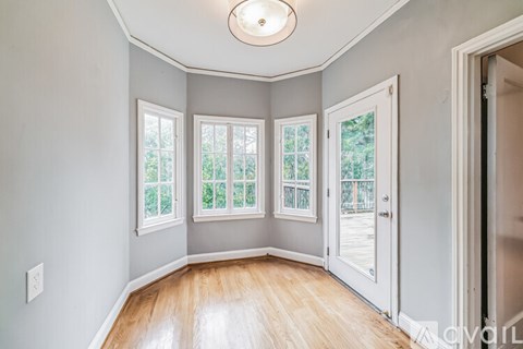 A room with a wooden floor and a white door.