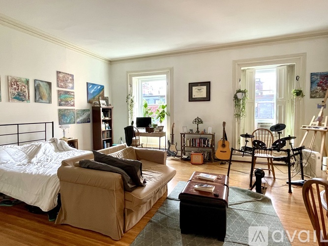 A living room with a couch, chair, and guitar.