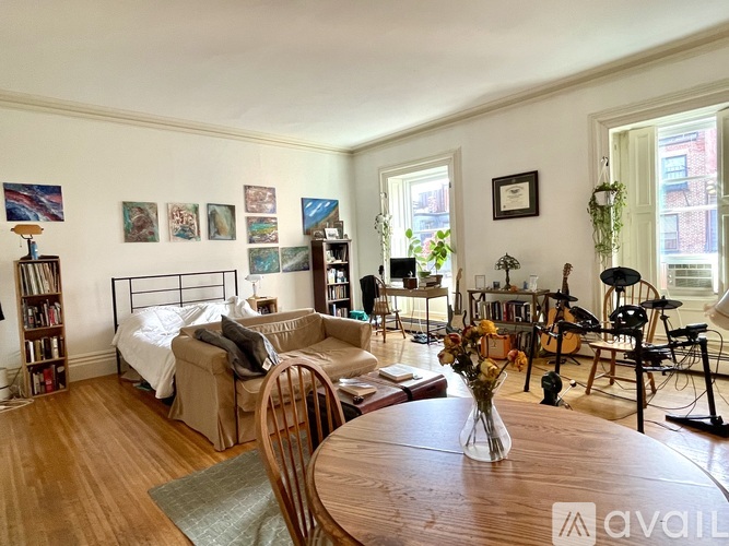 A living room with a couch, chair, and bookshelf.