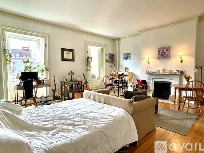 A bedroom with a large bed and a fireplace.