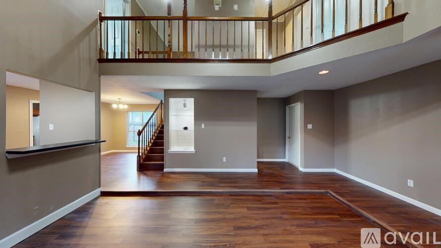A spacious living room with a staircase leading to the upper floor.