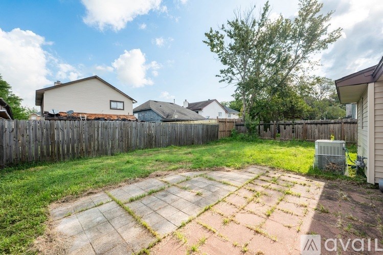 A room with a ceiling fan and a window showing a view of a street.