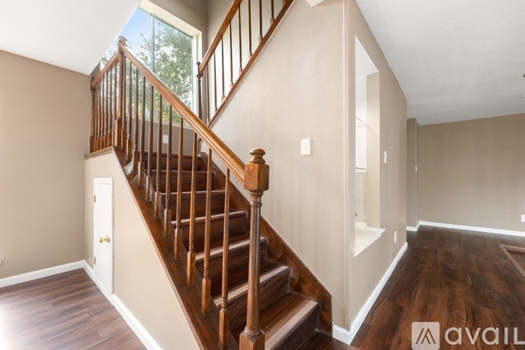 A spacious room with wooden floors and white walls.