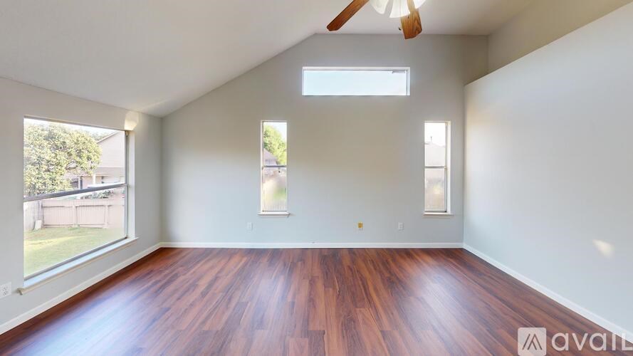 A room with wooden floors and a ceiling fan.