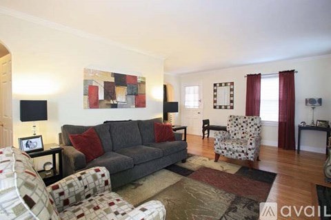 A living room with a grey couch and a patterned chair.
