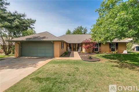 A house with a brown roof and a grey garage door is for sale.