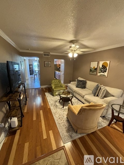 A living room with a white couch and a wooden floor.
