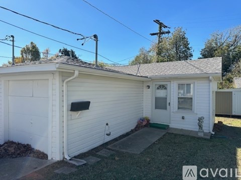 A small white house with a garage door and a window.