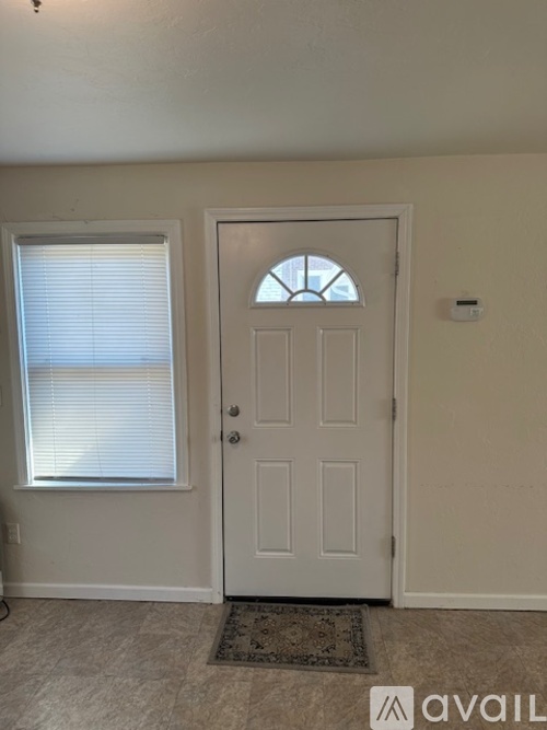 A white door with a window to the left and a small window above the door.