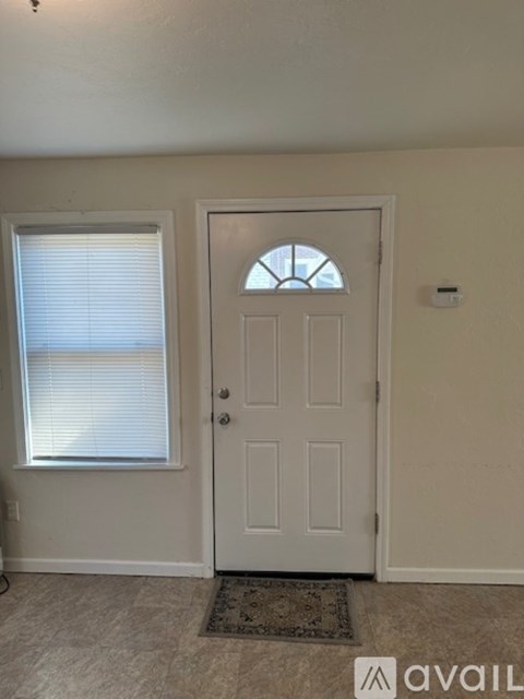 A white door with a window to the left and a small window above the door.