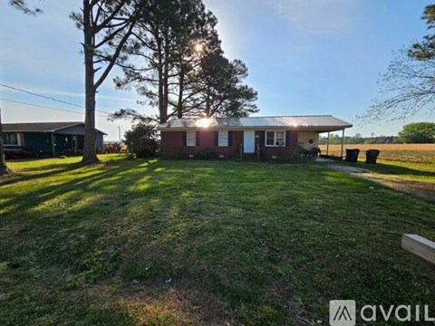 A house with a yard and a tree in front of it.