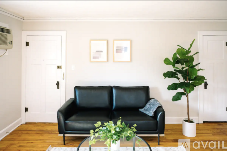 A living room with a black leather couch, a television, and a coffee table.