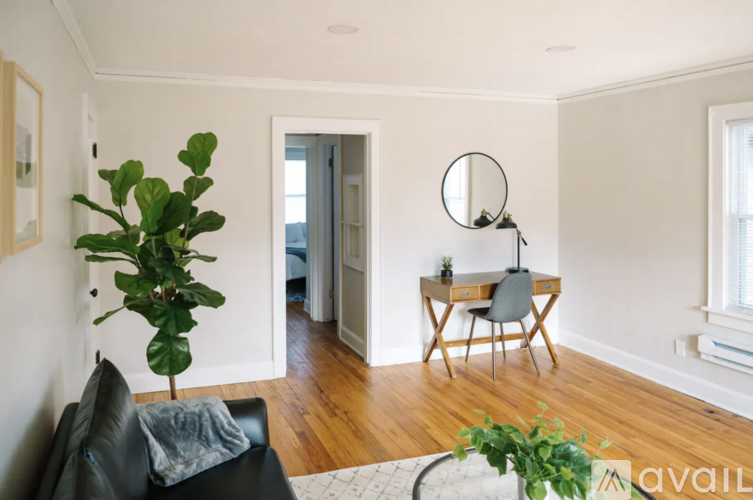 A room with a desk, chair, mirror, and a television.