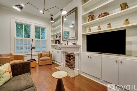 A living room with a fireplace and a television on the wall.