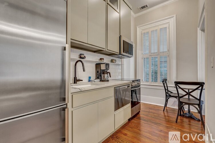 A kitchen with a stainless steel refrigerator and wooden floors.
